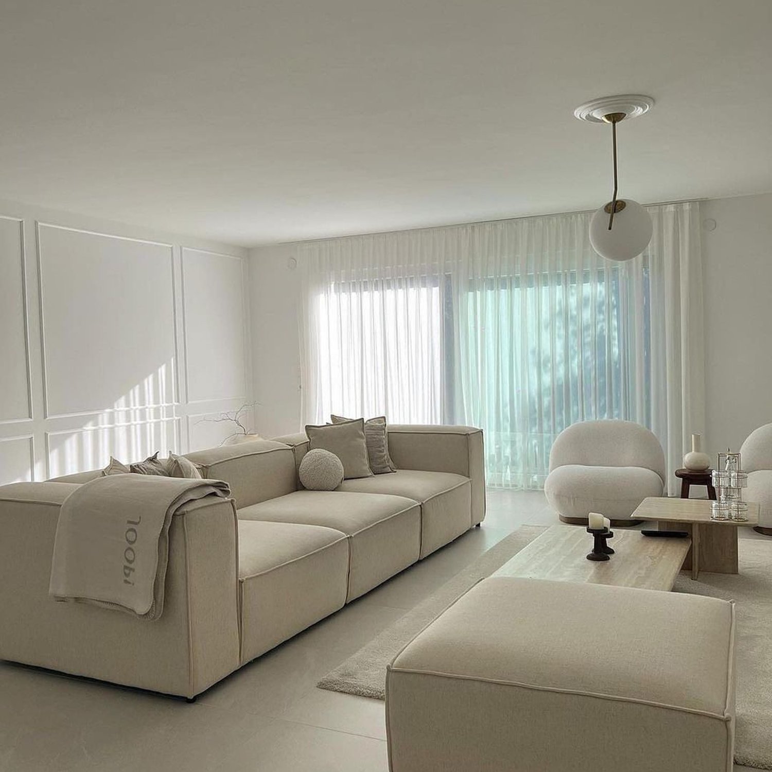 A modern minimalist living room with harmonious cream tones