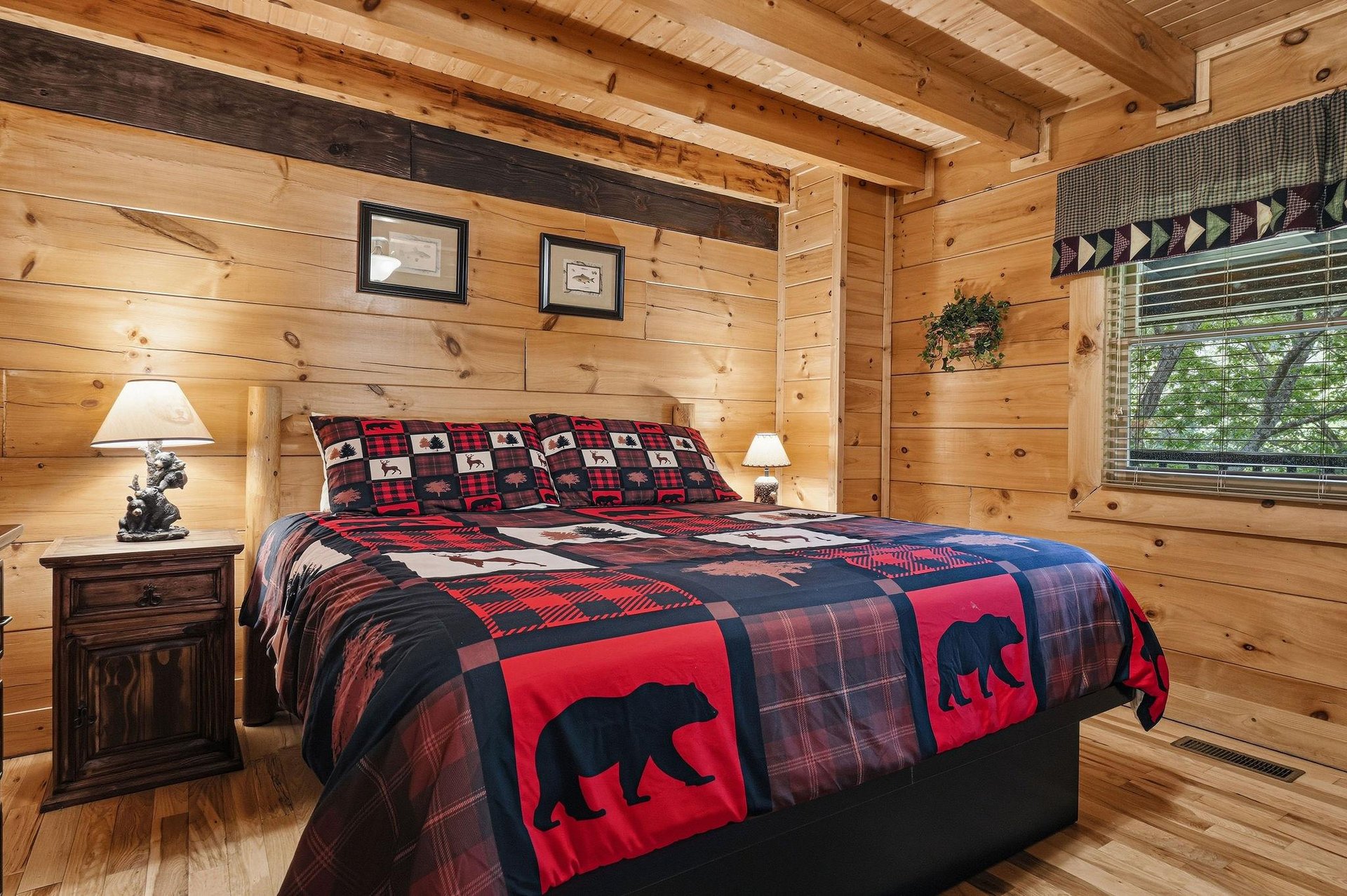 Cozy log cabin bedroom with rustic charm, featuring bearthemed bedding and warm wood surroundings for your peaceful mountain retreat.