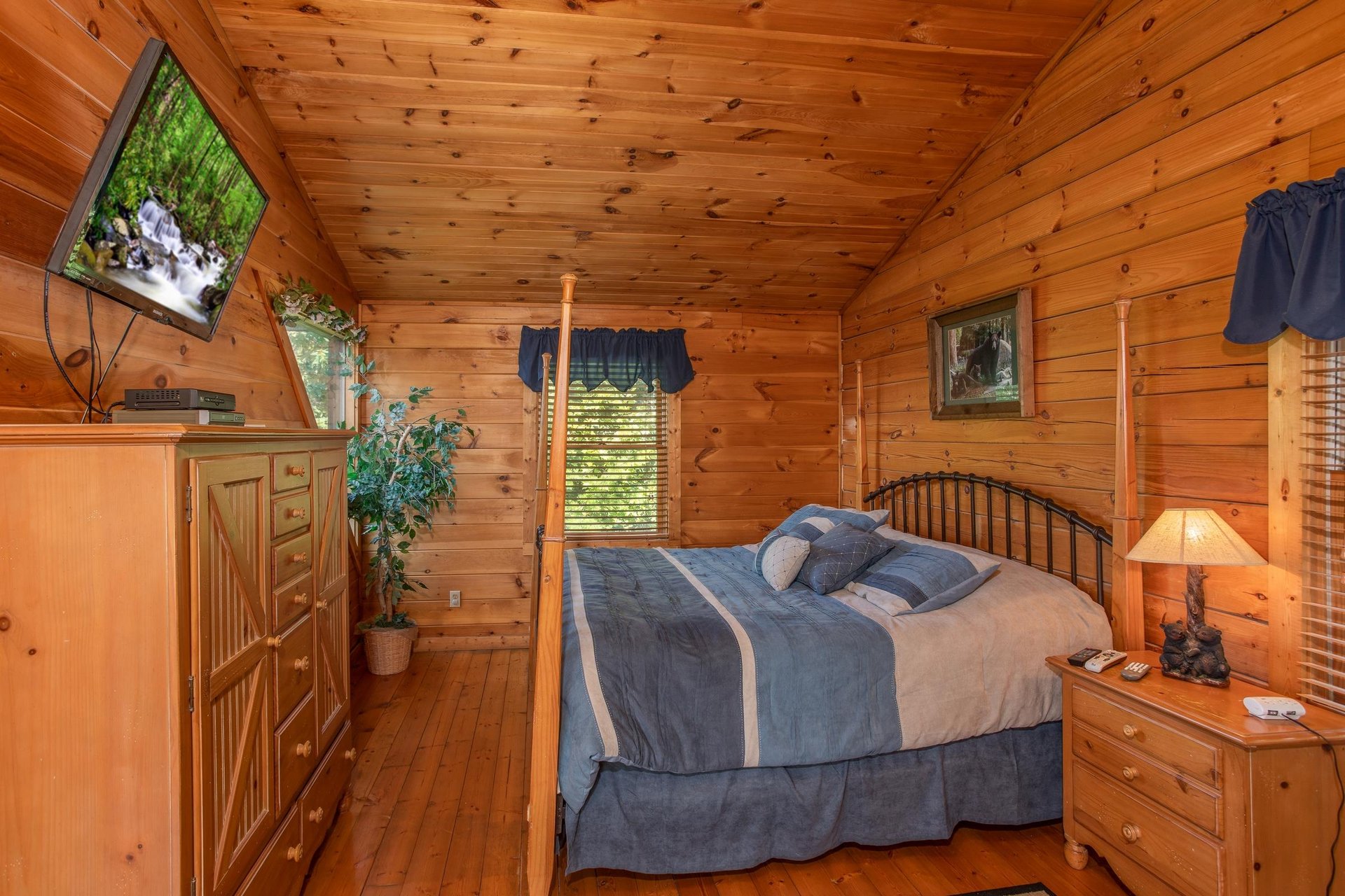 bedroom with four post bed and television at angels majestic view a 3 bedroom cabin rental located in pigeon forge