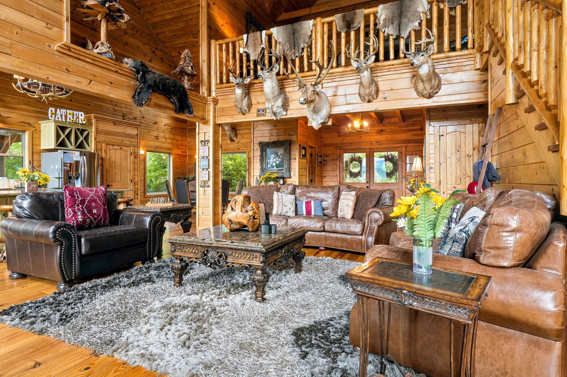 Relax in your spacious living room with vaulted ceilings, rich wood accents, and plush leather seating that invites you to unwind after a day outdoors.