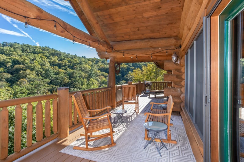 Outdoor seating with string lighting on the covered deck at Great View Lodge, a 5bedroom cabin rental located in Pigeon Forge