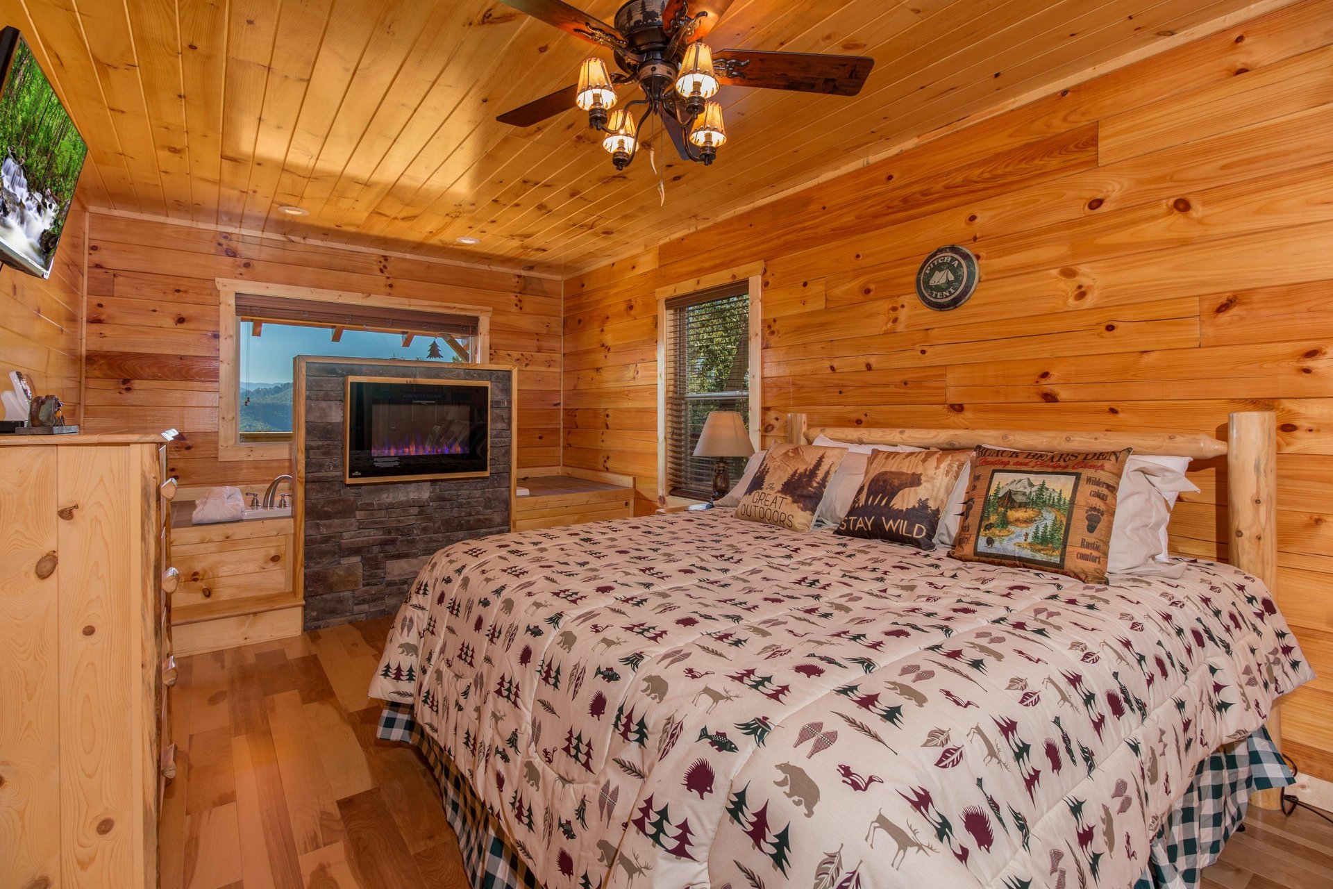 King bed and fireplace in a bedroom at Canyon Camp Falls, a 2 bedroom cabin rental located in Pigeon Forge