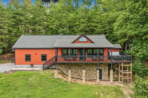 The property sits nestled among lush greenery, offering a peaceful mountain setting for your getaway. A spacious wraparound deck and stonefoundation lower level provide ample outdoor space to enjoy t