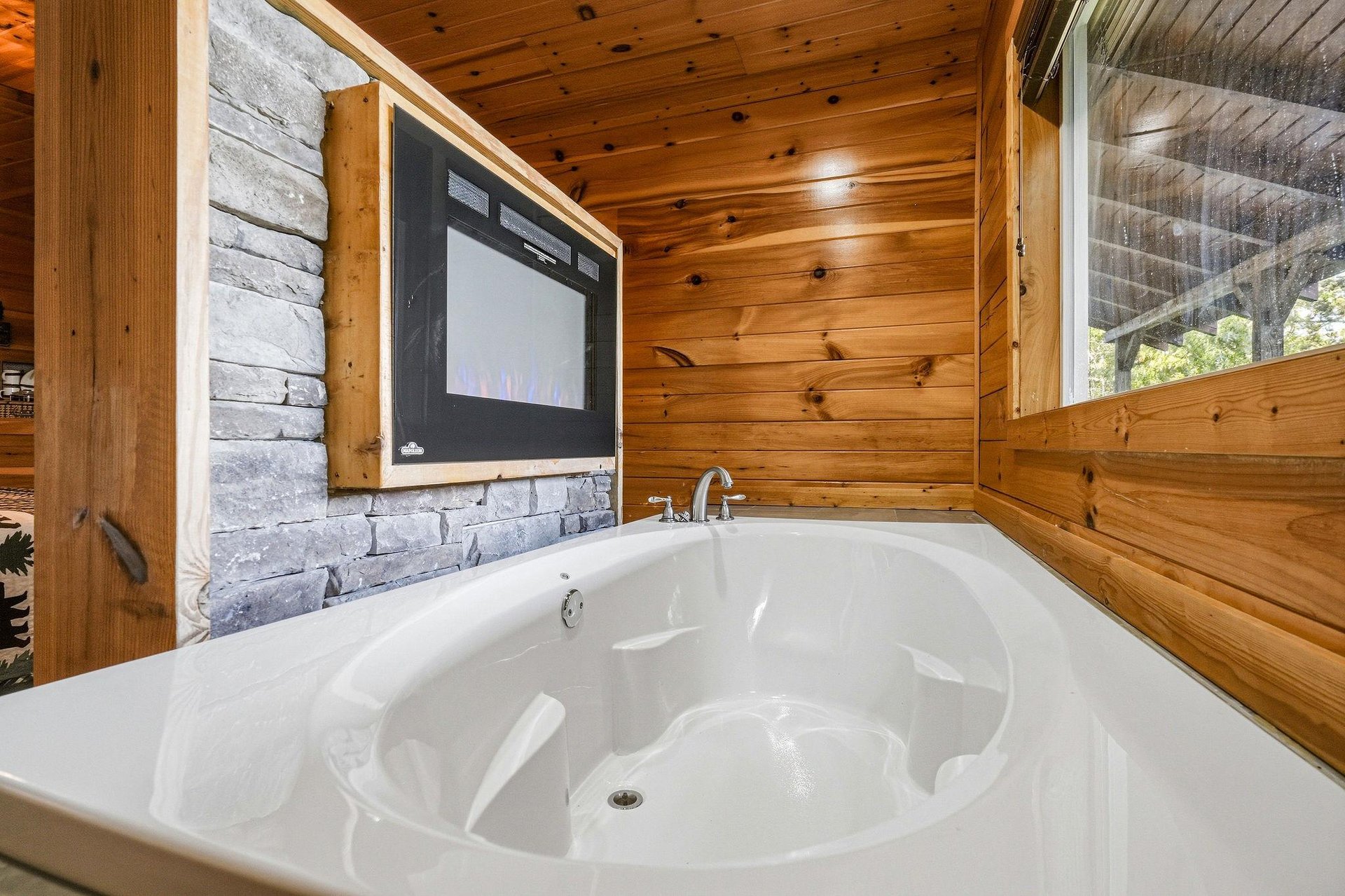 Unwind in your private hot tub surrounded by warm wood and natural light, with a builtin TV to complete your ultimate relaxation retreat.