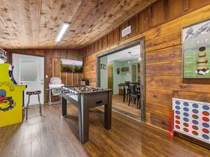 Your private game room features foosball, arcade games, and rustic wood charm for endless entertainment.