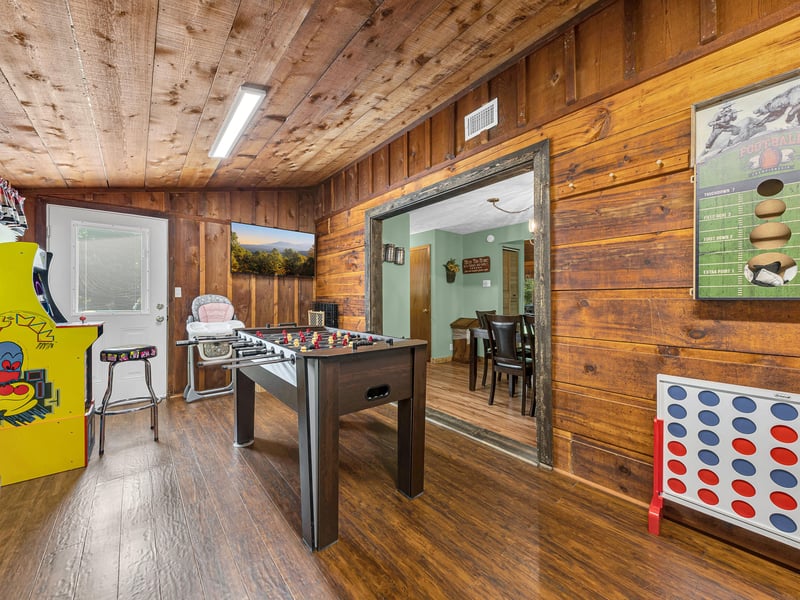 Your private game room features foosball, arcade games, and rustic wood charm for endless entertainment.