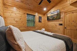Drift off in your cozy log cabin bedroom, where warm wood surrounds you and mountain artwork inspires dreams of adventure.