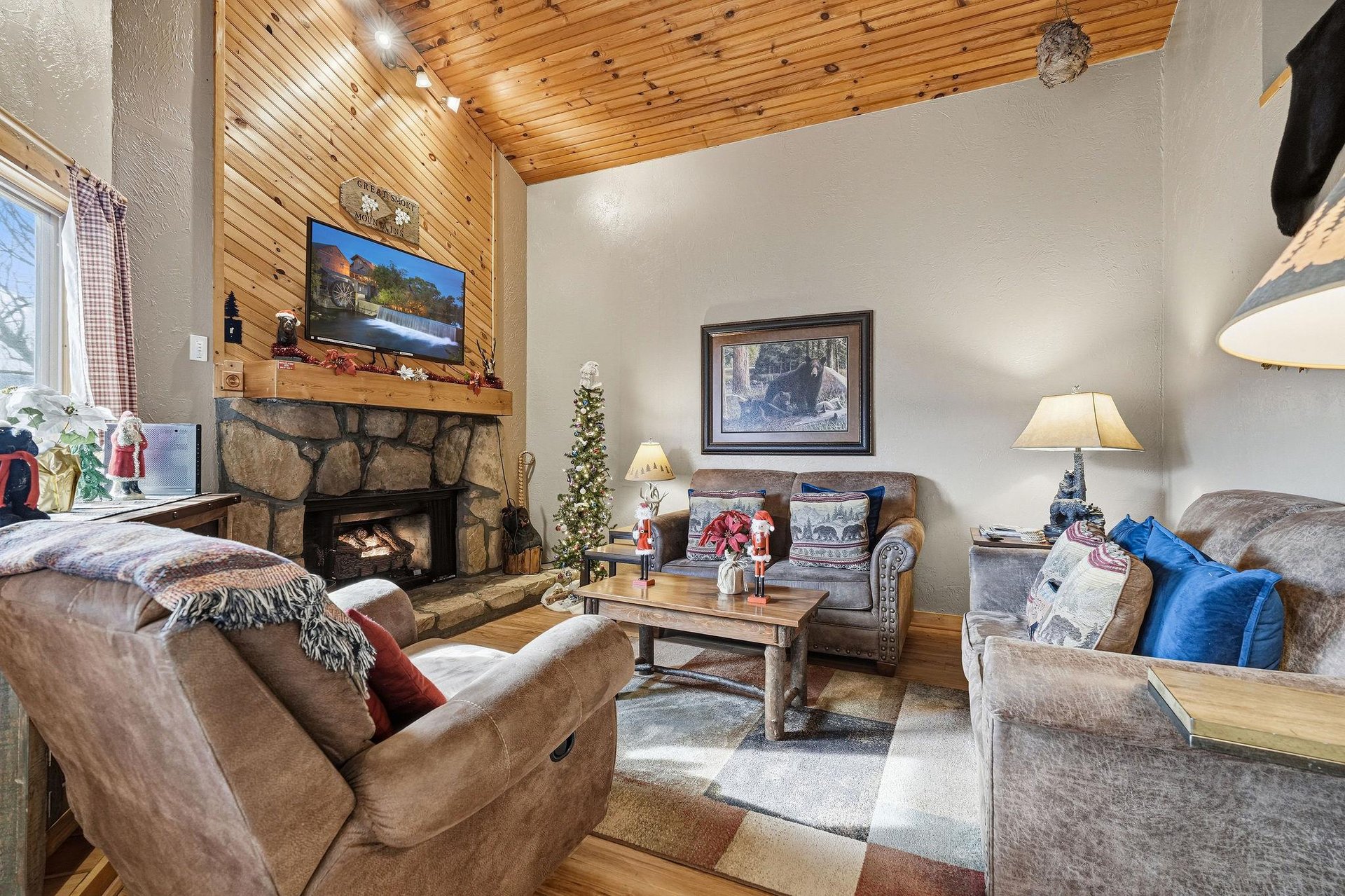 Curl up in your cozy living room with rustic wood ceilings, stone fireplace, and plush seating for perfect mountain evenings.