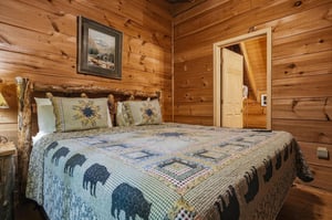 Drift off in this charming bedroom with its handcrafted log bed frame, warm wooden walls, and cozy cabin atmosphere that wraps you in mountain charm.