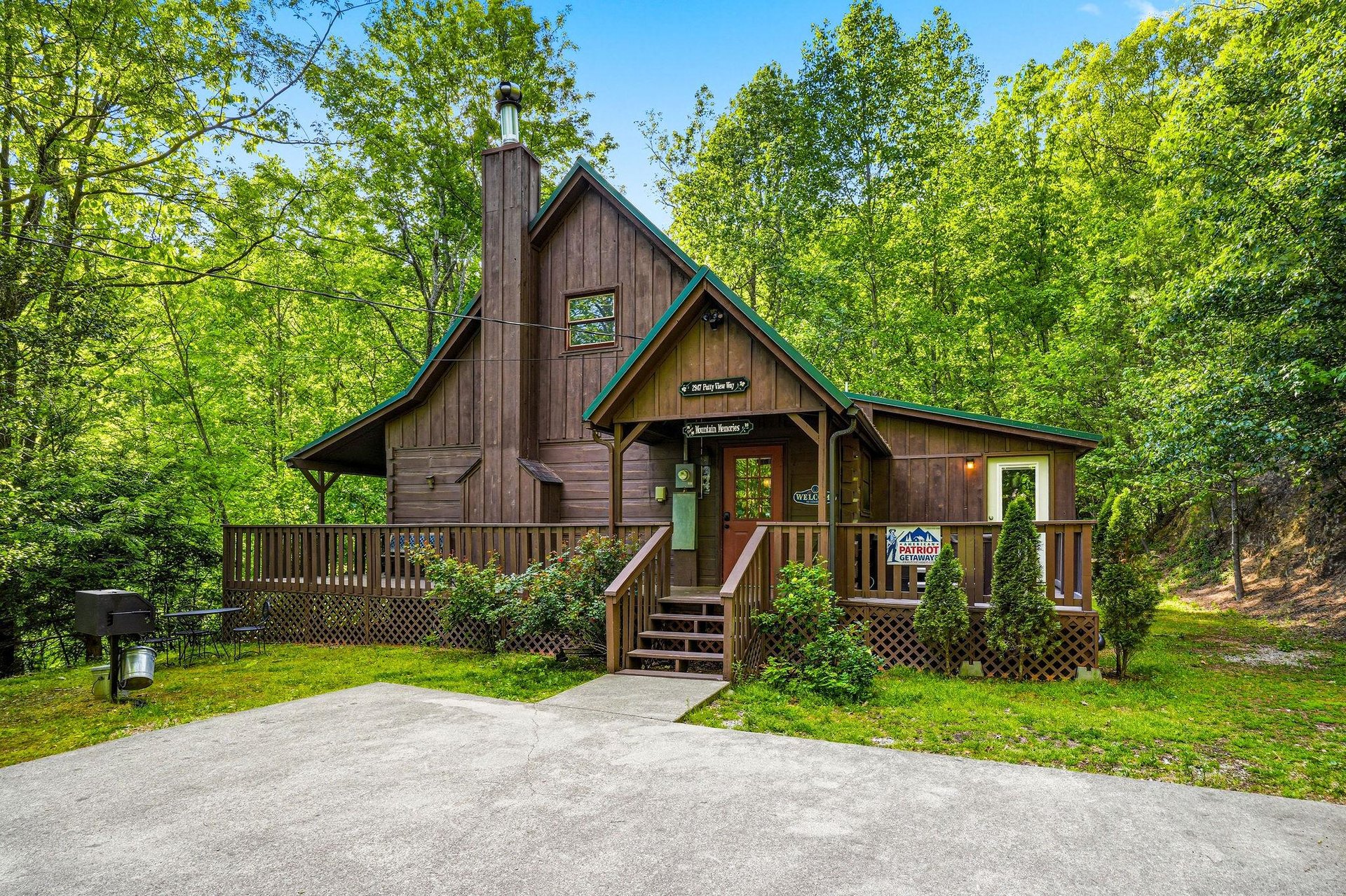 Charming wooden cabin nestled among towering trees, featuring a welcoming front porch and peaceful forest setting for your mountain getaway.