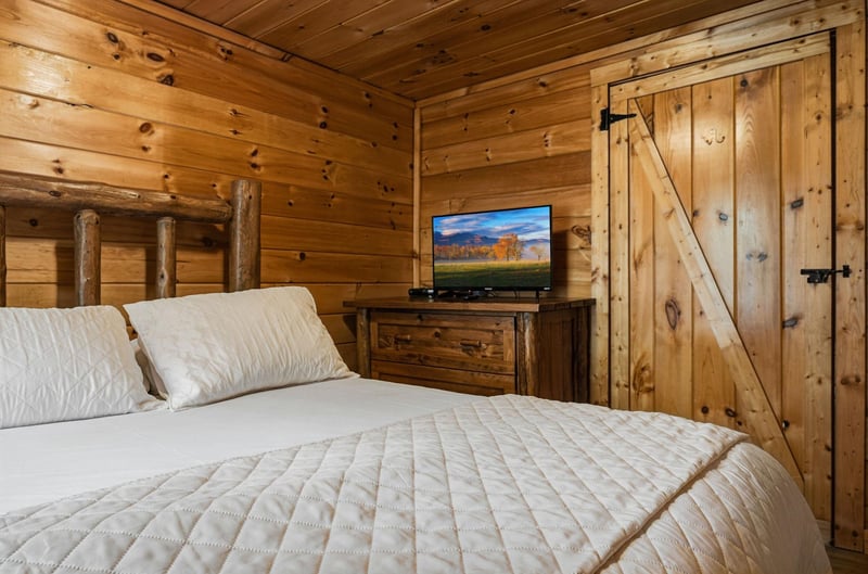 Wrap yourself in rustic luxury with warm wood walls, crisp linens, and your own TV for cozy mountain evenings.