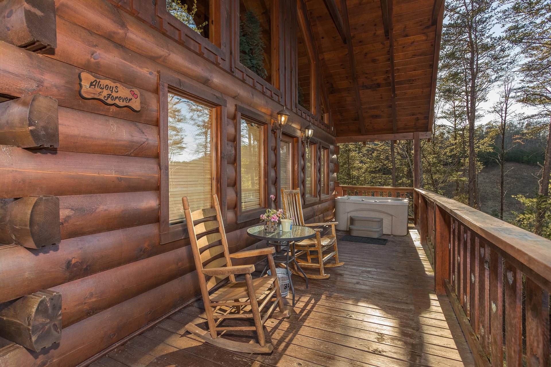 rocking chairs and hot tub on a covered deck at always  forever a 1 bedroom cabin rental located in pigeon forge