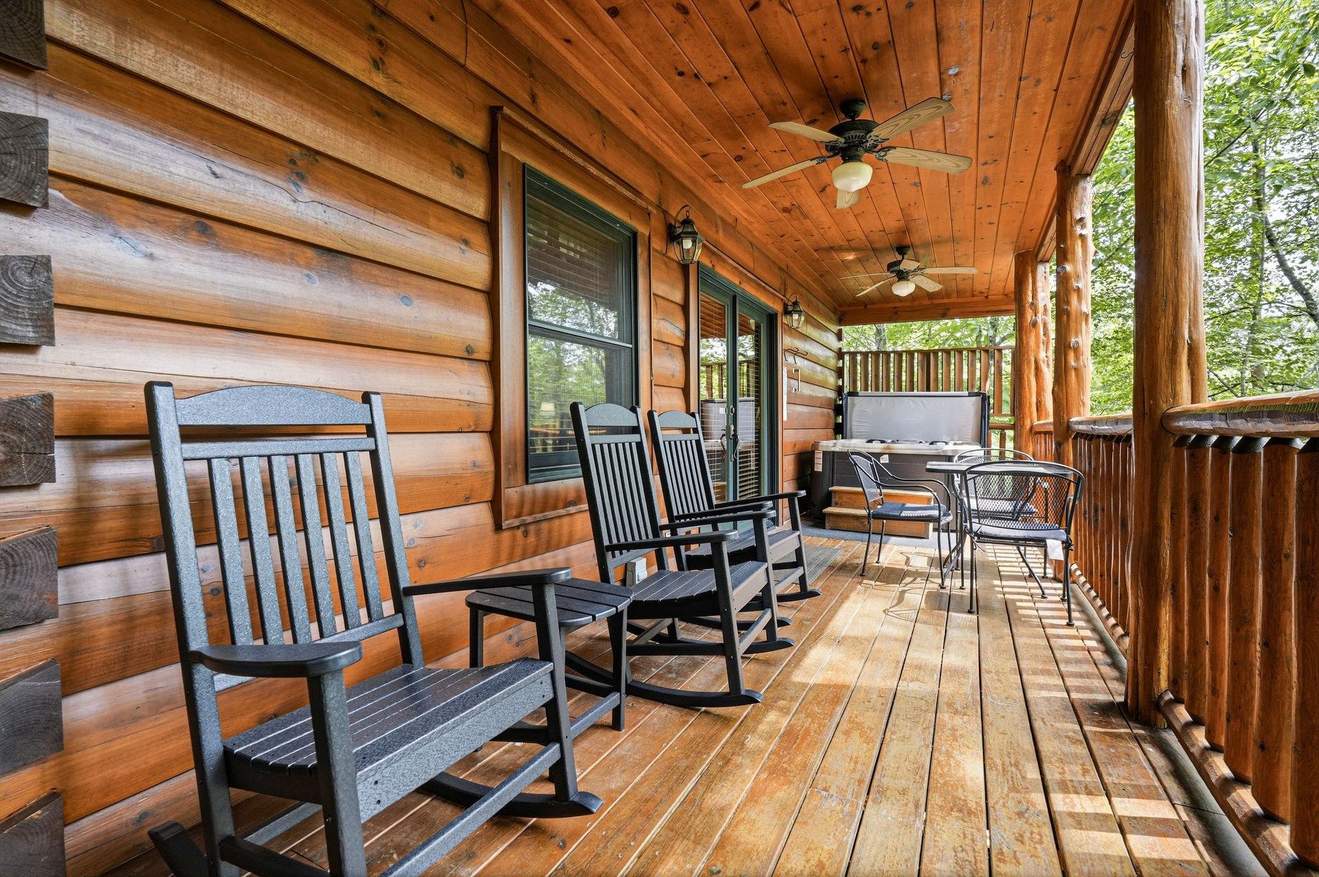 Settle into your private deck with rocking chairs and a hot tub, where warm wood tones and gentle ceiling fans create your perfect outdoor retreat.