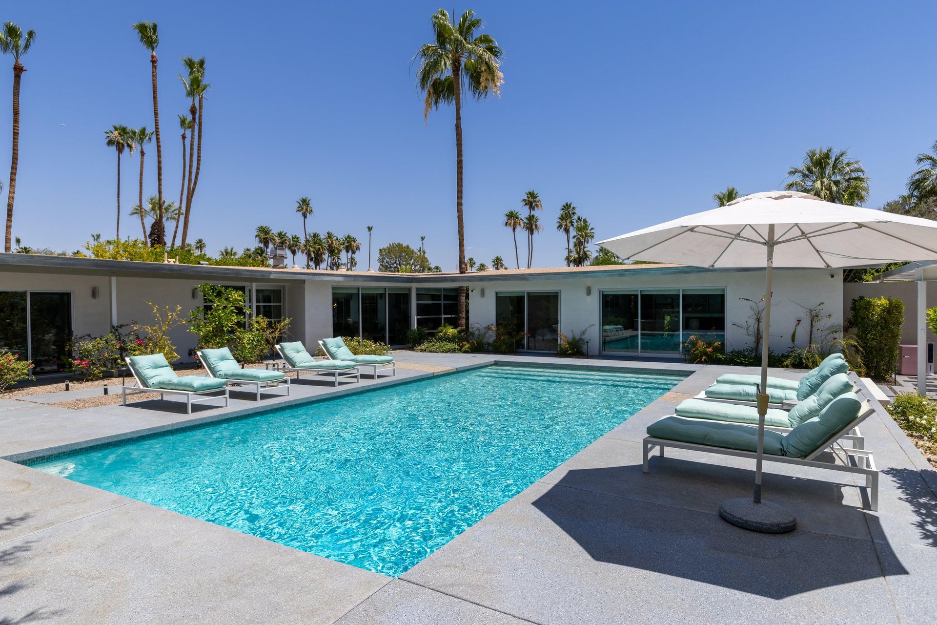 Private poolspa with sun loungers and umbrellas.
