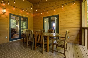 Gather around this charming outdoor dining space, where warm string lights and natural wood create the perfect setting for memorable meals under the covered deck.