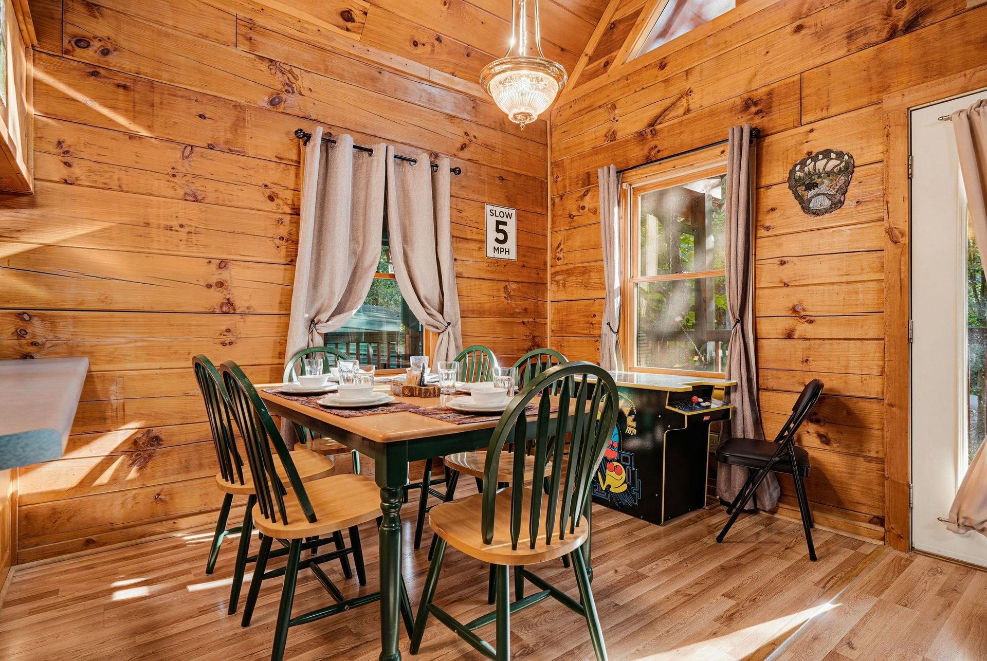Gather around the rustic dining table where warm wood walls and soft natural light create a cozy setting for your meals and conversation.