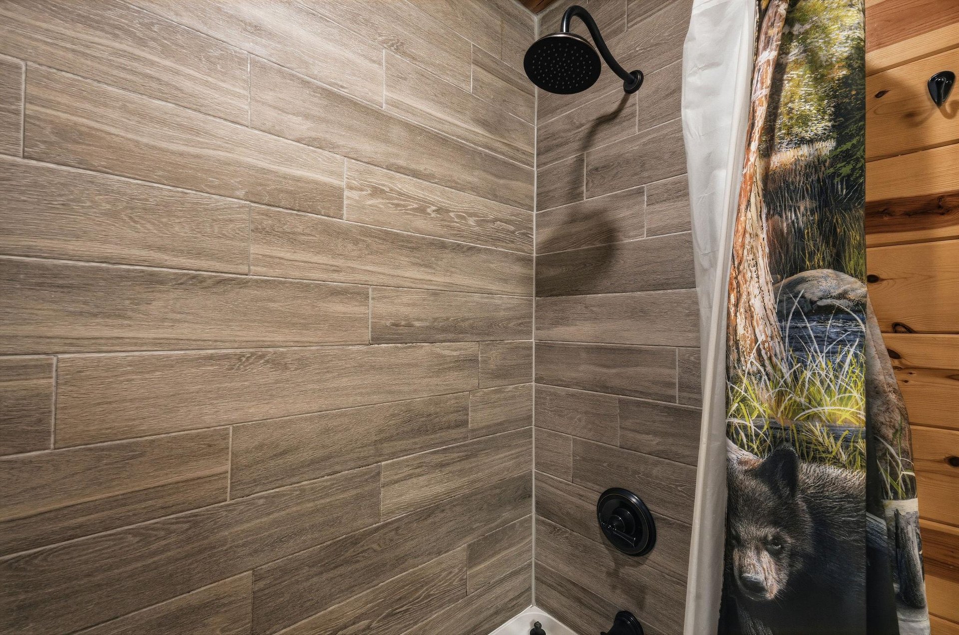 Step into your private shower with woodlook tile, sleek fixtures, and a rainfall showerhead that makes every rinse feel rejuvenating.