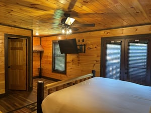 Drift off in your cozy log cabin bedroom, where warm wood tones and a peaceful ambiance create the perfect retreat after your mountain adventures.