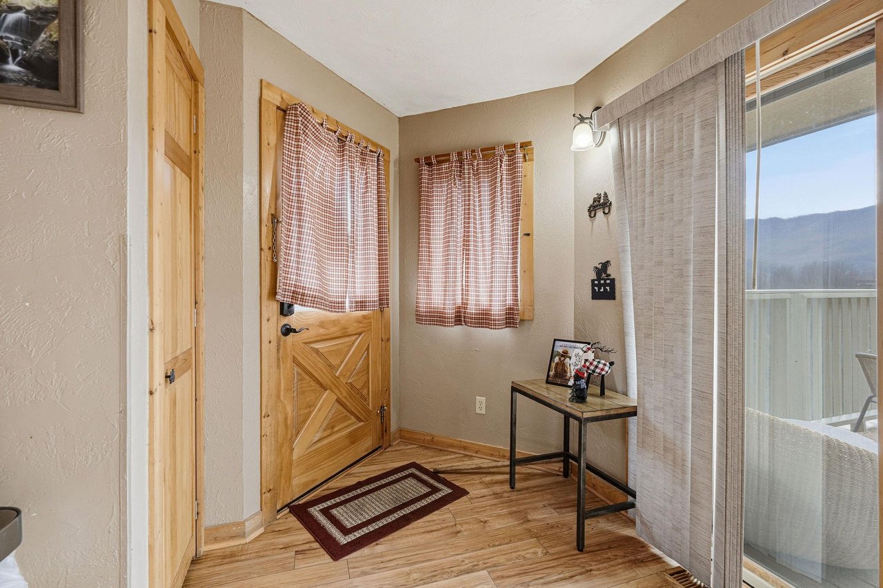 Step into your charming entryway with rustic wood accents and cozy plaid curtains welcoming you home.