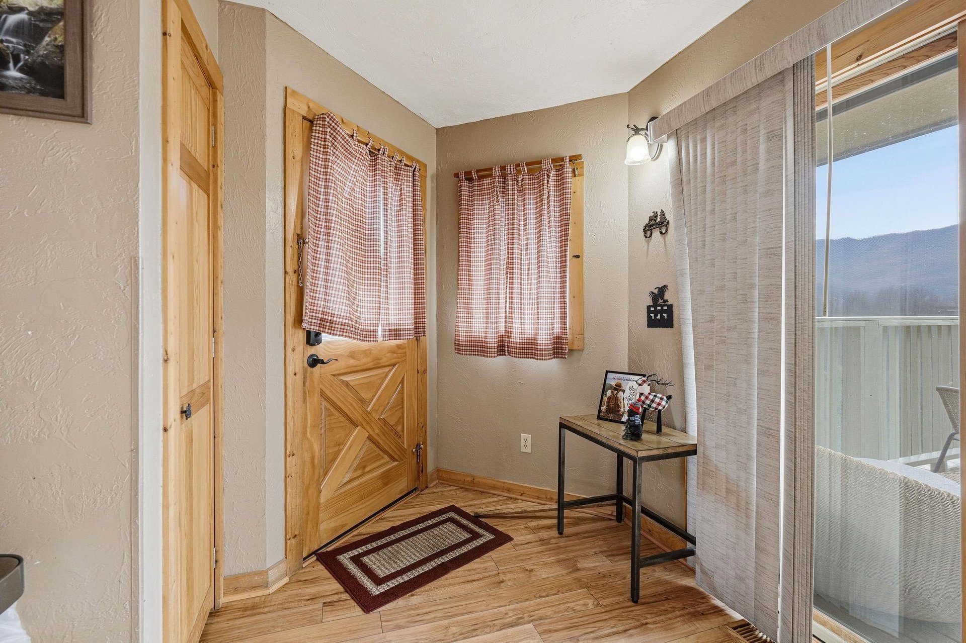 Step into your charming entryway with rustic wood accents and cozy plaid curtains welcoming you home.