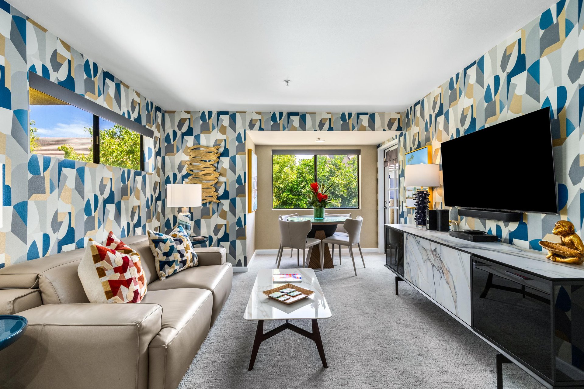 Cozy couch, flatscreen TV, dining area, and balcony access.