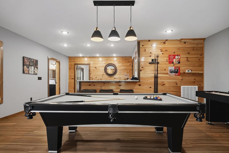 Challenge your crew to a game on this sleek blackfelt pool table. Modern lighting and warm wood accents create the perfect backdrop for friendly competition and latenight fun.