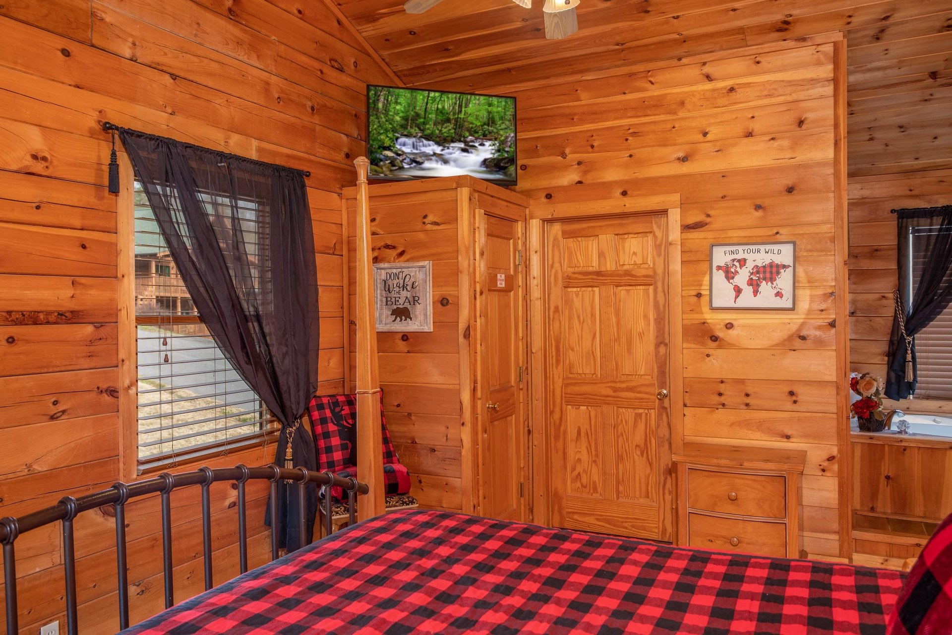 Bedroom with a television and inroom jacuzzi at Hibernation Station, a 3bedroom cabin rental located in Pigeon Forge