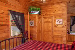 Bedroom with a television and inroom jacuzzi at Hibernation Station, a 3bedroom cabin rental located in Pigeon Forge
