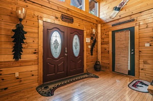 Step inside this charming cabin where rustic wood paneling and unique decor instantly make you feel at home. The warm, inviting entrance welcomes you to your mountain retreat.