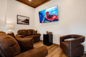 Sink into plush seating and enjoy movie nights on your large flatscreen TV, all beneath a warm woodbeamed ceiling that adds rustic charm to your retreat.