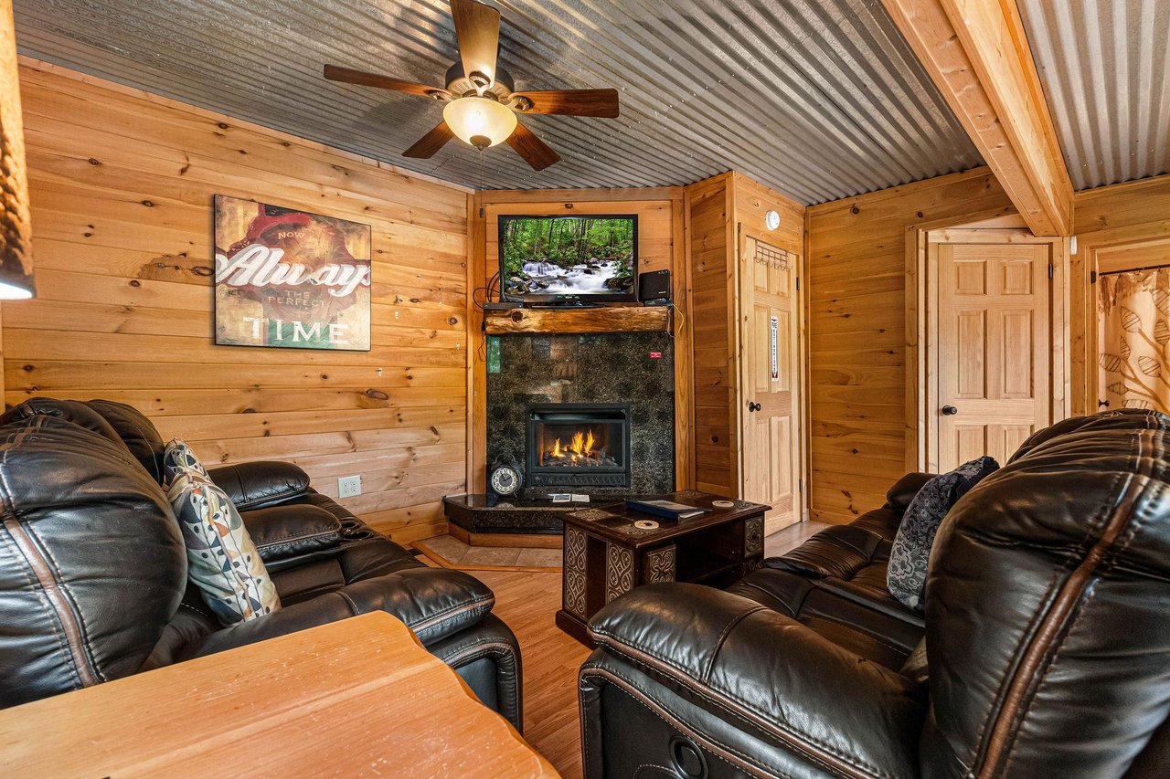 Living room with a corner fireplace and TV at License to Chill, a 3 bedroom cabin rental located in Gatlinburg