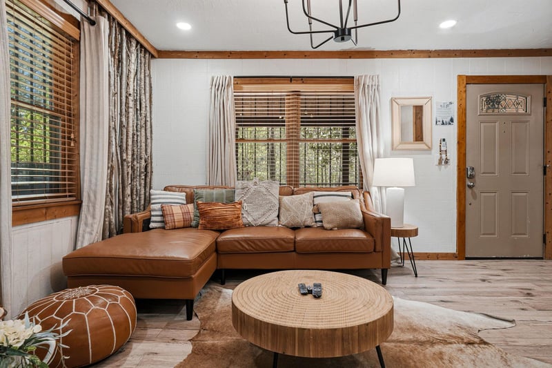 Sink into plush leather seating while natural light filters through wooden blinds in your cozy living space.