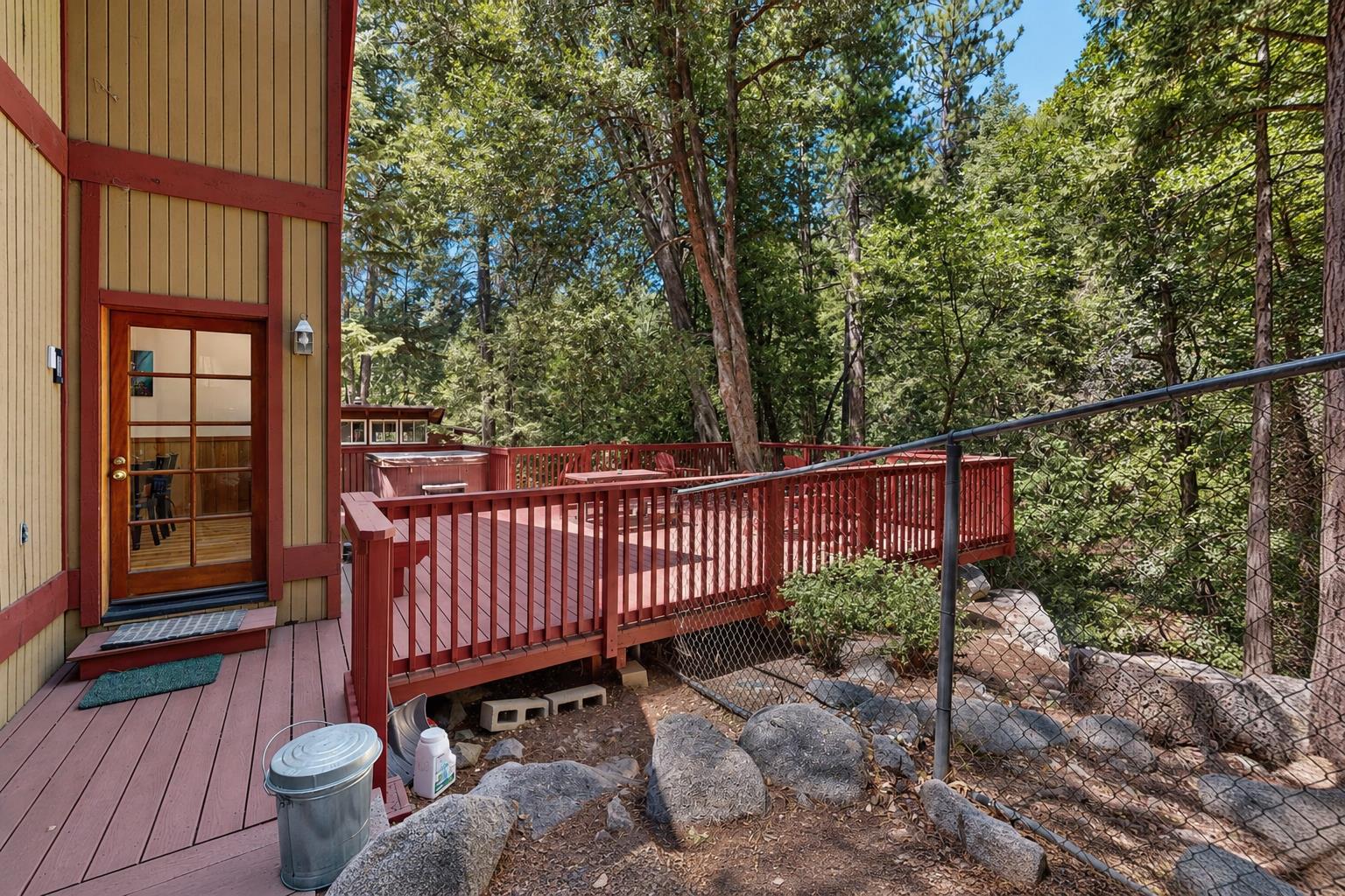 The back door opens right onto the deck, tucked among granite boulders and towering pines — an easy indooroutdoor connection to the cabins private outdoor space.