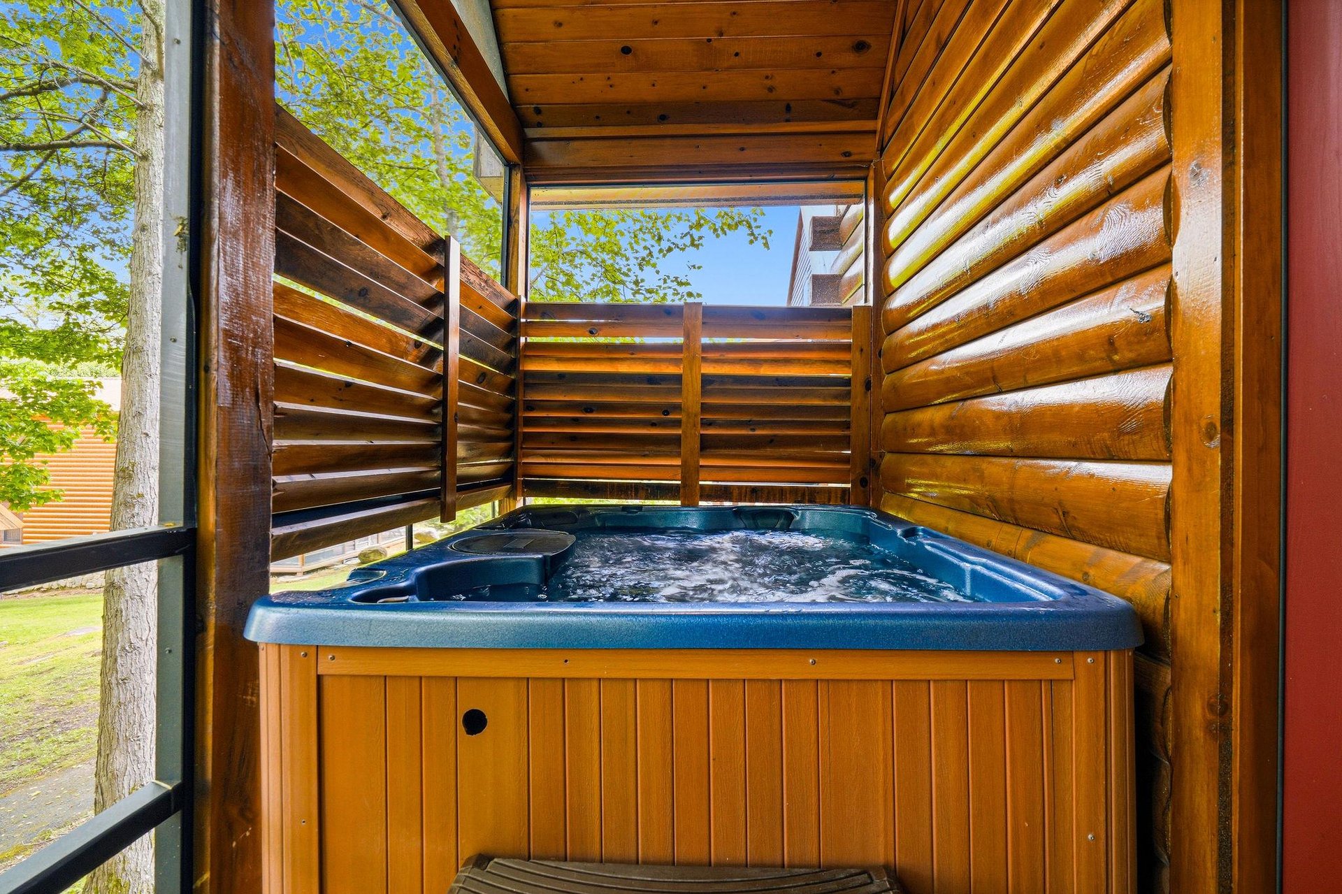 Your private hot tub sanctuary awaits, sheltered by warm wood screens for intimate relaxation under open skies.