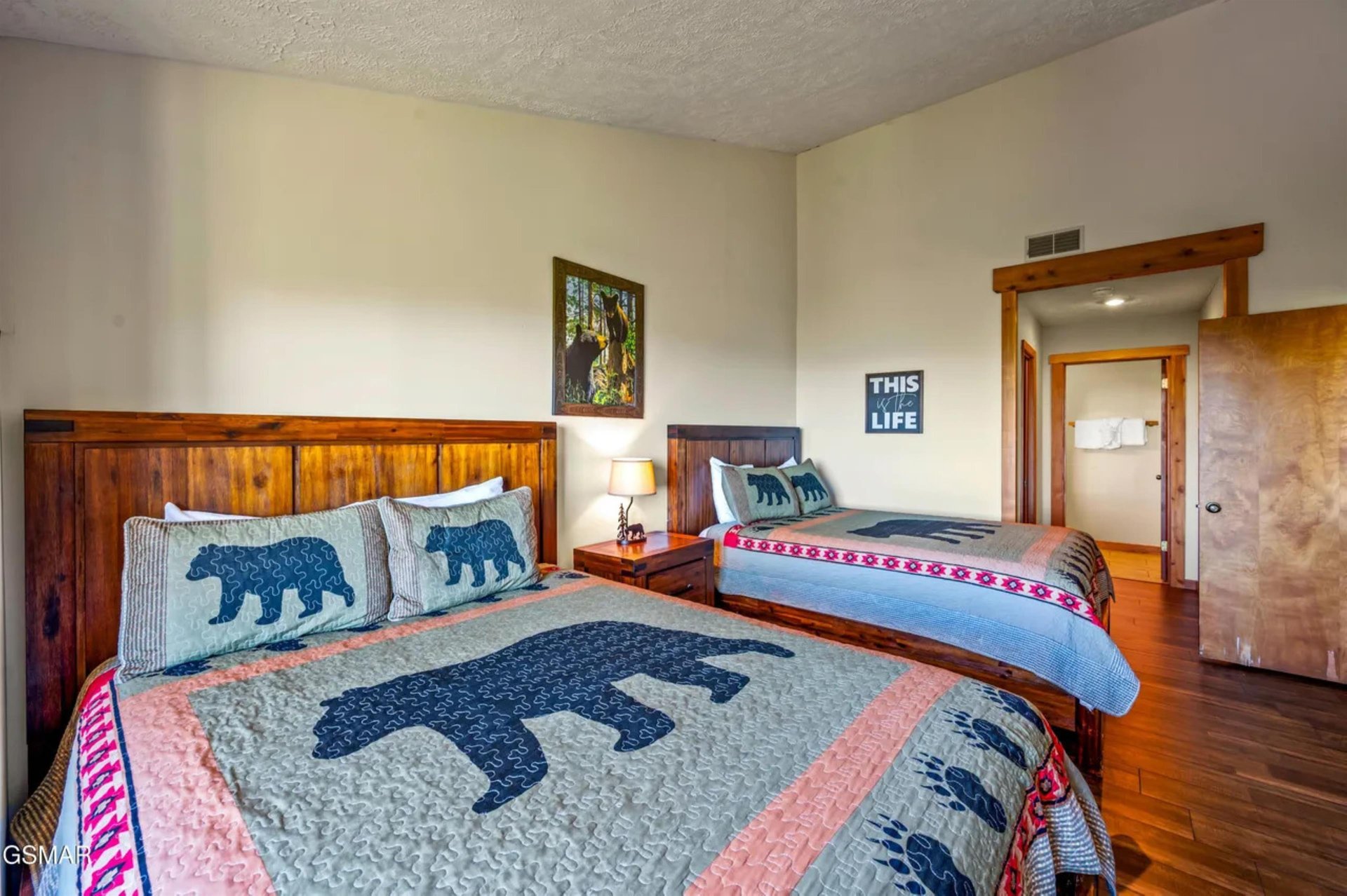 Sink into cozy comfort in this charming bedroom with rustic wood furnishings and whimsical bearthemed bedding that invites restful nights.