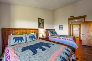 Sink into cozy comfort in this charming bedroom with rustic wood furnishings and whimsical bearthemed bedding that invites restful nights.