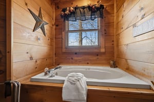 Sink into your private soaking tub surrounded by warm wood walls, where fluffy towels and forest views create your perfect retreat.