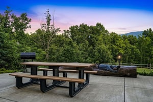 Property nestled in lush forested surroundings beneath mountains, offering natural tranquility at arrival.