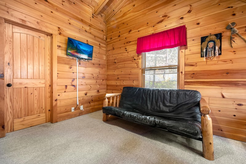 Bedroom with a log bed and futon at Alpine Sondance, a 2 bedroom cabin rental located in Pigeon Forge