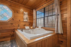 Sink into your private soaking tub surrounded by warm wood walls, where rustic charm meets relaxation in this intimate retreat.
