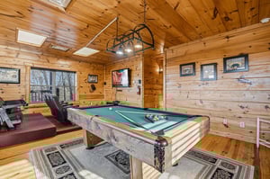 Challenge friends to pool while exercising nearby—your perfect retreat combines rustic cabin charm with entertainment and fitness in one inviting space.