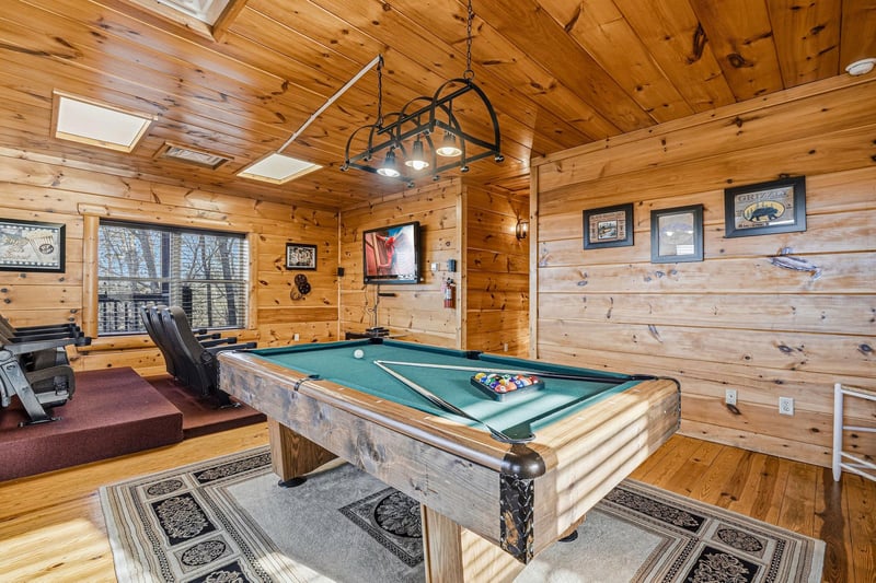 Challenge friends to pool while exercising nearby—your perfect retreat combines rustic cabin charm with entertainment and fitness in one inviting space.