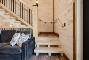 Sink into the plush sofa and feel the warmth of natural wood surround you. The open design invites relaxation while you plan your next adventure upstairs.