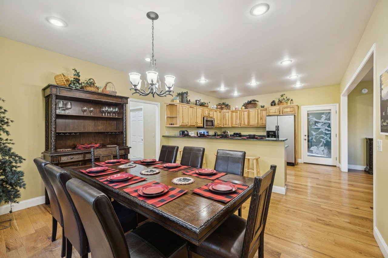 Gather around this spacious dining table, beautifully set for your group meals. The open layout connects you to the fullyequipped kitchen, making hosting dinners a breeze.