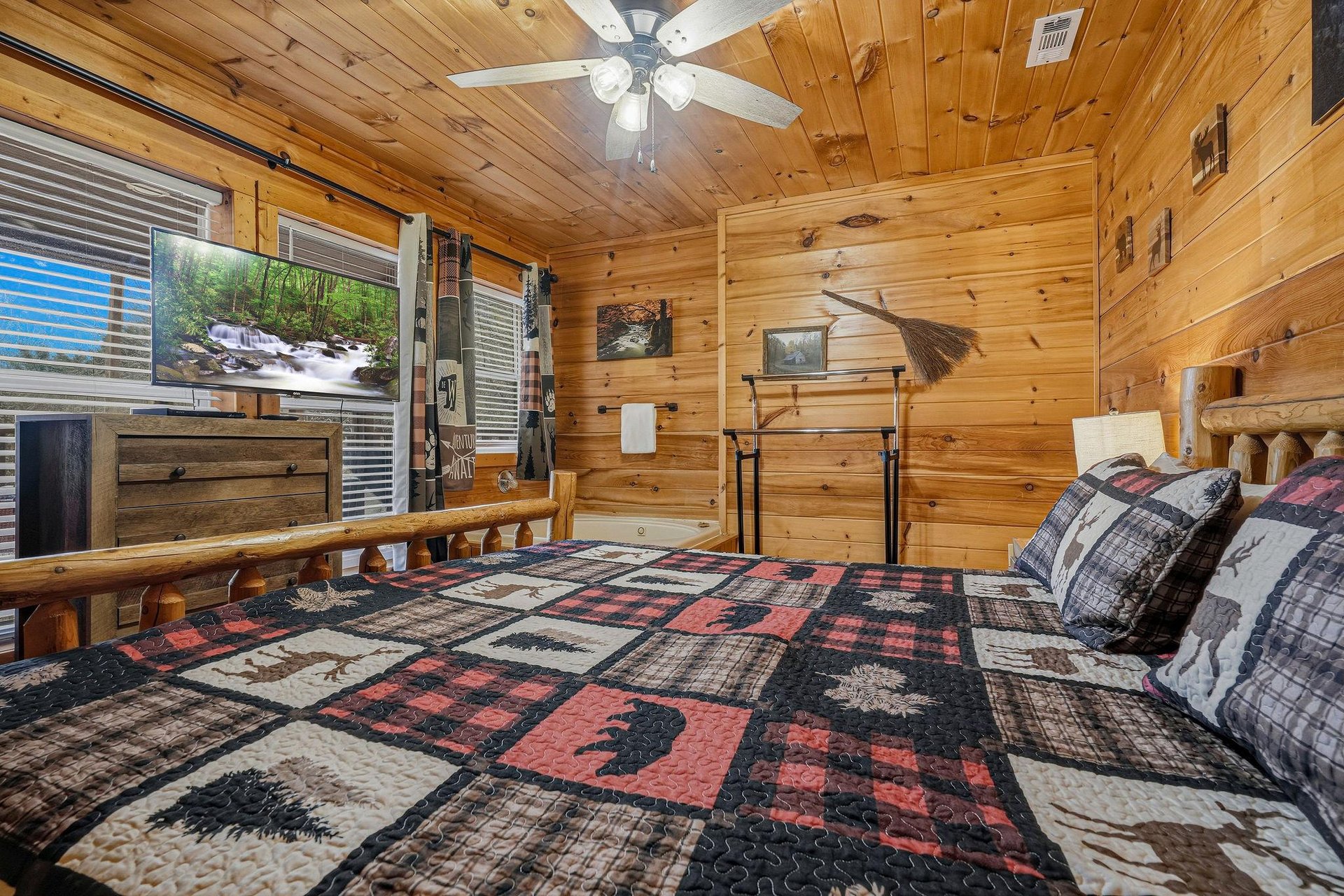 Drift off in this cozy log cabin bedroom, wrapped in rustic charm with knotty pine walls and wildernessthemed bedding.