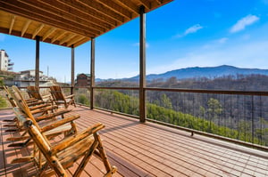 Unwind in rustic wooden chairs on your covered deck, soaking in breathtaking mountain views that stretch endlessly before you.
