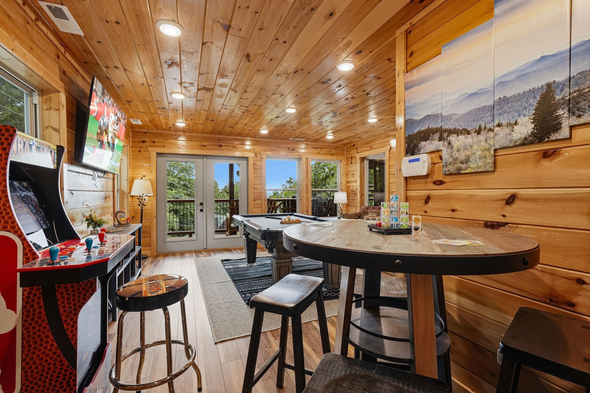 Challenge friends to pool or arcade games in this woodpaneled entertainment space, where floortoceiling windows frame scenic mountain views and invite natural light to fill your playful afternoons.