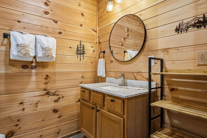 Warm wood paneling and rustic accents set the tone for your mountain retreat, with fresh towels waiting and a peaceful spot to freshen up after your days adventures.