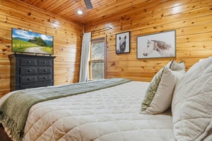 Drift off in your cozy log cabin bedroom, where warm wood surrounds you and charming horse artwork creates rustic tranquility.
