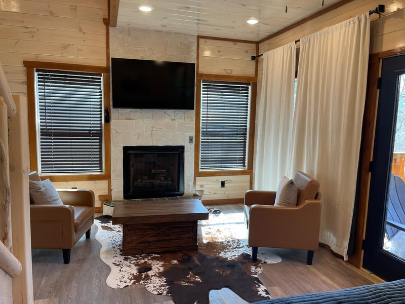 Curl up by your private fireplace in this cozy living space, where rustic wood meets modern comfort for perfect mountain retreat vibes.